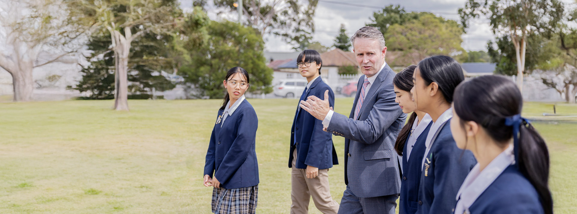 Students walking with their principal Stephen Kennaugh at St Andrews College Marayong