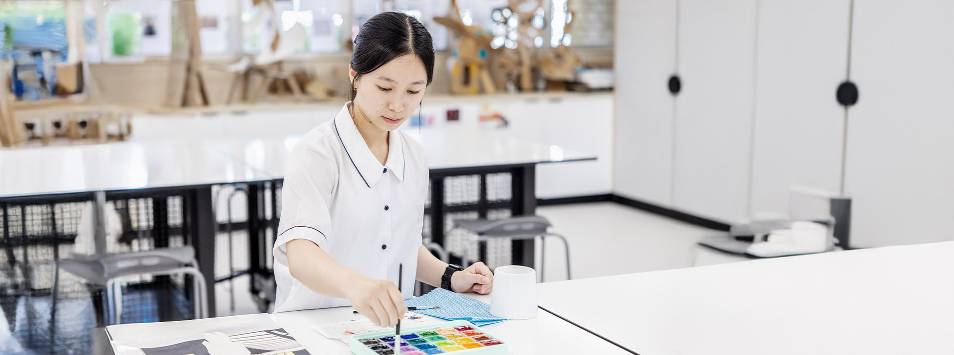 Student working on her artwork in the classroom at St Andrews College Marayong