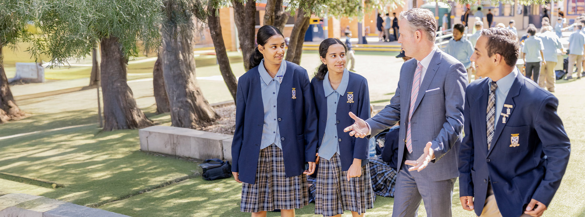 Students walking with their principal Stephen Kennaugh at St Andrews College Marayong