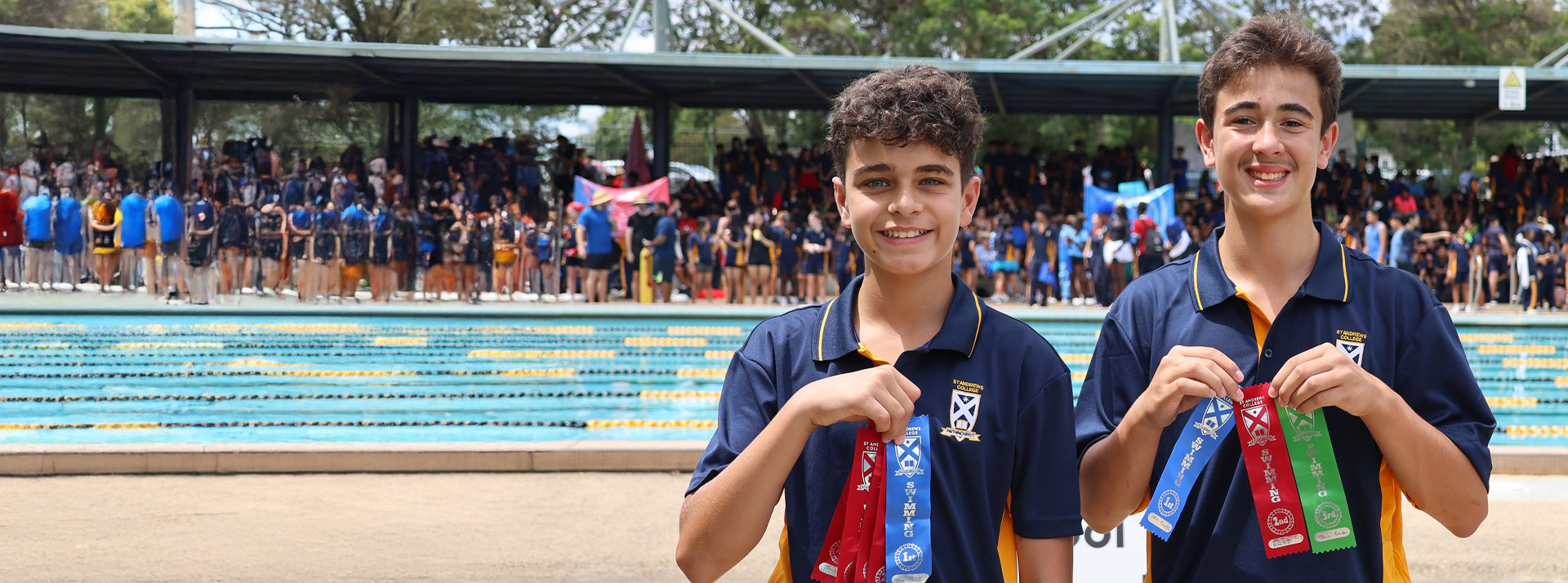 Students holding their place ribbons they earned at the St Andrews College Marayong swimming carnival