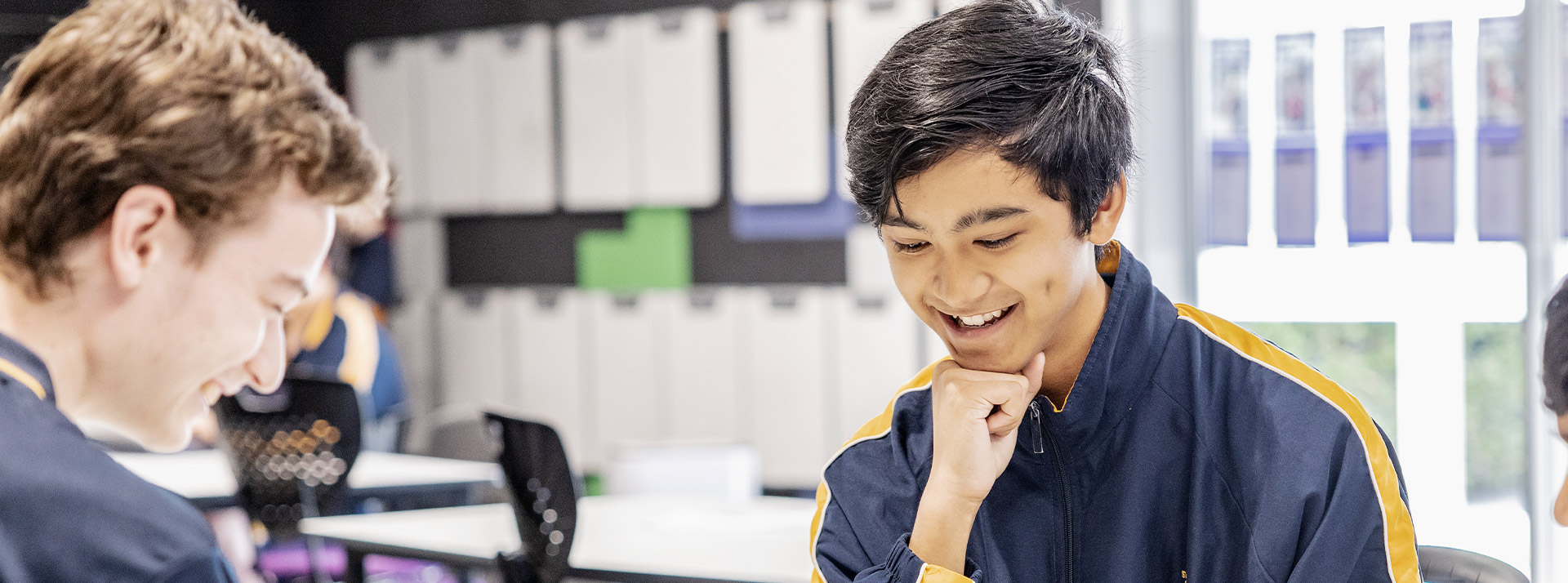 Student smiling in the library at St Andrews College Marayong