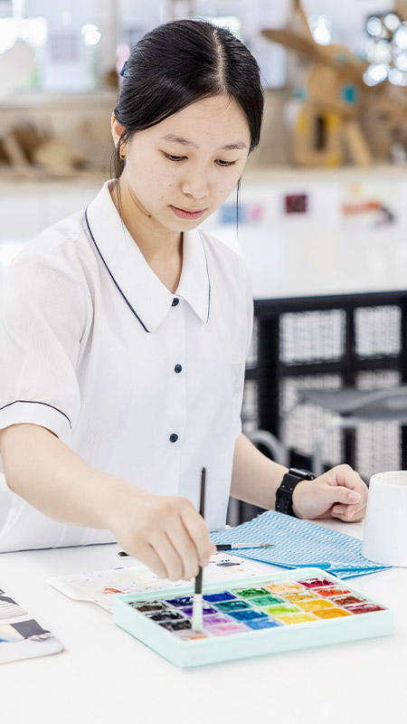 Student working on her artwork in the classroom at St Andrews College Marayong