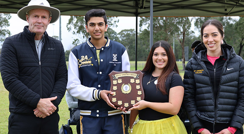 Students holding a trophy representing their college house at St Andrews College Marayong
