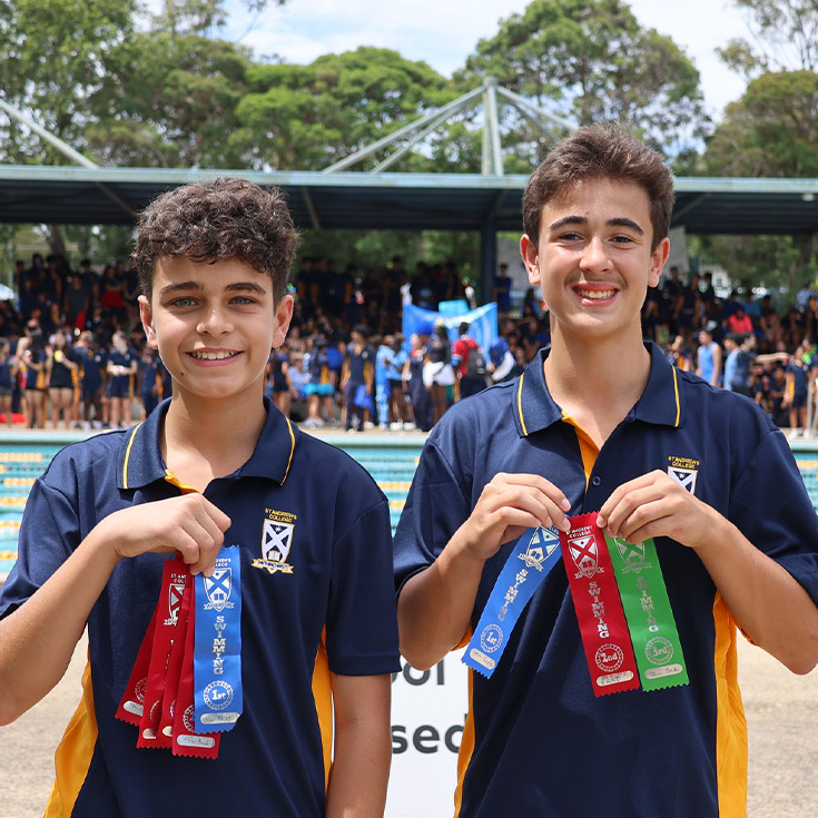 Students holding their place ribbons they earned at the St Andrews College Marayong swimming carnival